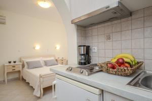 a kitchen with a sink and a bowl of fruit next to a bed at Orkos Blue Coast in Mikri Vigla