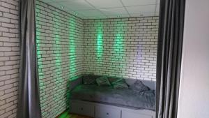 uma parede de tijolos com um sofá num quarto com luzes verdes em Agro Relax Nowodwór em Nowodwór