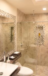 y baño con ducha, aseo y lavamanos. en Hotel Castilla Real, en Pereira