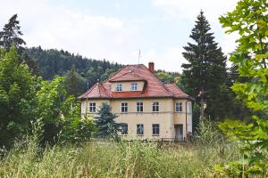 an old house with a red roof on a hill at Karolina in Polanica-Zdrój
