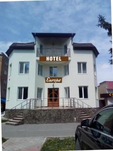 een groot wit hotel met een hotelbord erop bij Hotel Europe in Khmilnyk