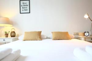 Una cama blanca con dos almohadas encima. en Mañuel by Smiling Rentals en Hondarribia