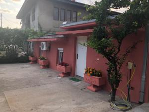 Een rood huis met sinaasappels op de deur. bij Apartmani Pavicevic in Podgorica