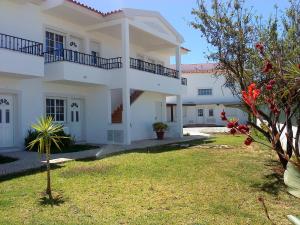 a large white house with a yard in front of it at RC - Pata Residence in Albufeira