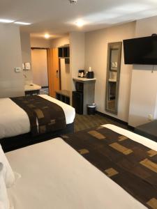 Habitación de hotel con 2 camas y TV en Kelly Inn West Yellowstone en West Yellowstone