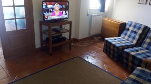 a living room with two chairs and a television at Casa da praia in Nazaré