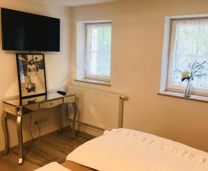 a room with a bed and a television on a wall at Ferienheim Kuckuckswinkel in Schöna