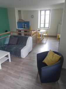 Una sala de estar con una cama, un sofá y una mesa. en Gite Saint Nicolas, en Paray-le-Monial