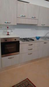 a kitchen with white cabinets and a stove top oven at lake house in Mezzanego +15 photos