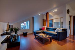 een woonkamer met een blauwe bank en een tafel bij Apartman NANE in Rab