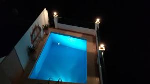 - une piscine bleue au milieu d'une maison la nuit dans l'établissement Casa Raquel, à Frigiliana