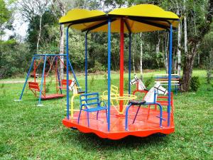 a playground with colorful chairs and a swing at Ózera Hotel Fazenda in Prudentópolis