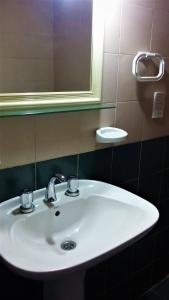 a white sink in a bathroom with a mirror at Mis Casitas in Chajarí +4 photos