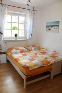 een bed in een slaapkamer met een raam bij Seestern in Werdum