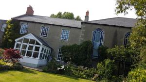 a house with a large window and a yard at The Old Manse in Lowick
