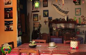 a dining room with a wooden table and a room with a table and chairs at Apapacho Hostel in Tilcara