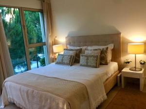 トロイアにあるTróia Férias na Praiaのベッドルーム1室(枕付きのベッド1台、窓付)