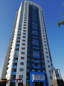 a tall building with blue windows and a blue sky at ObolonSky in Kyiv