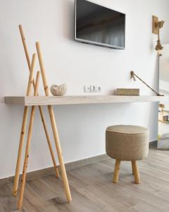 a desk with a chair and a television on a wall at Angelos Boutique Suites in Patitiri