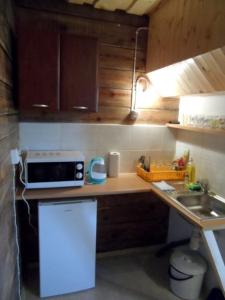 a small kitchen with a sink and a microwave at Domek z bala in Sejny