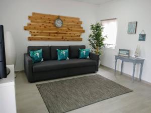 a living room with a couch and a clock on the wall at Casa do Relógio in Horta