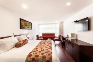 Schlafzimmer mit einem Bett, einem Schreibtisch und einem Stuhl in der Unterkunft Hotel Cuellars in Pasto