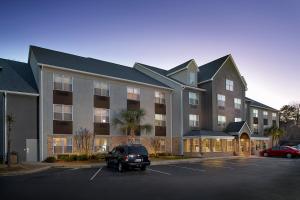 a building with a car parked in a parking lot at Country Inn & Suites by Radisson, Columbia Airport, SC in Columbia