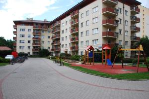ワルシャワにあるKasztanowa Apartamentの大きなアパートメントビルの前の遊び場