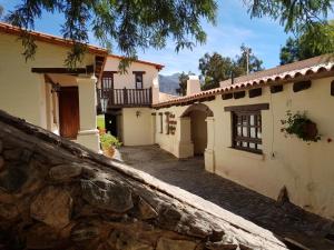 a house with a stone wall in front of it at El Molino de Cachi in Cachí