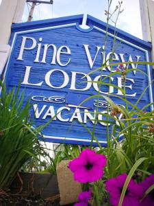un panneau bleu pour des vacances locales dans une vallée de pins dans l'établissement Pine View Lodge Old Orchard Beach, à Old Orchard Beach