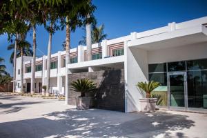 ein weißes Gebäude mit Palmen davor in der Unterkunft Hotel Maioris Navolato in San Pedro