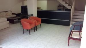 sala de estar con sillas de color naranja y sofá en Pousada Parque Ecológico en Indaiatuba