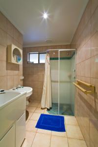 a bathroom with a shower, sink, and tub at Potshot Hotel Resort in Exmouth