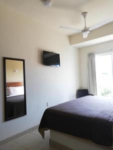 a bedroom with a bed and a tv on the wall at Hotel Nonni in Santa Cruz Huatulco
