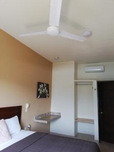 a bedroom with a bed and a ceiling fan at Hotel Nonni in Santa Cruz Huatulco