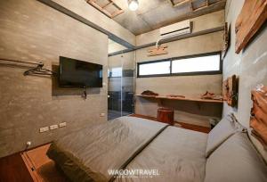 a bedroom with a bed and a flat screen tv at Pin Shiuan Inn in Xiaoliuqiu