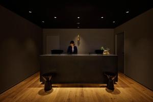 a person sitting at a counter in a room with two laptops at Hotel Resol Kyoto Kawaramachi Sanjo in Kyoto