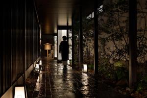 Hotel Resol Kyoto Kawaramachi Sanjo في كيوتو: شخص يسير في الممر في الليل
