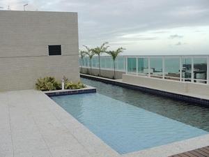 un edificio con piscina frente a un edificio en Condominio jtr brasil en Maceió