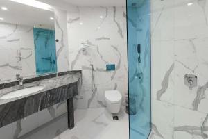 a bathroom with a toilet and a sink and a shower at Best Western PLUS Premium Inn in Sunny Beach