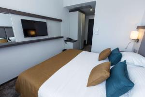 a bedroom with a large bed with blue pillows at Best Western PLUS Premium Inn in Sunny Beach