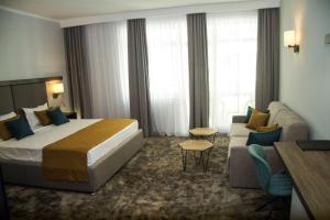 a hotel room with a large bed and a couch at Best Western PLUS Premium Inn in Sunny Beach