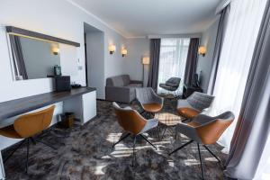 a living room with chairs and a table in a hotel room at Best Western PLUS Premium Inn in Sunny Beach