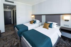 a hotel room with two beds with blue and white at Best Western PLUS Premium Inn in Sunny Beach