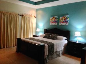 1 dormitorio con 1 cama grande y paredes azules en Hotel Boutique Casa D' Luna, en Choluteca