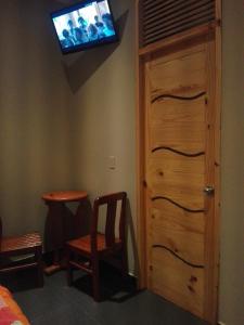 Habitación con puerta y TV en la pared en La Posada Del Misti, en Arequipa