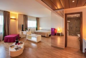 ein Hotelzimmer mit einem Bett und einem Wohnzimmer in der Unterkunft Best Western Plus Leone di Messapia Hotel & Conference in Lecce