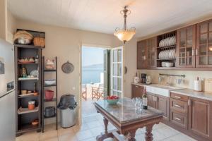 a kitchen with a table and a view of the ocean at Panasea Villa Naxos in Kalando