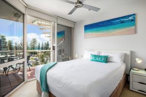una camera con un grande letto e un balcone di Sandcastles Mooloolaba a Mooloolaba