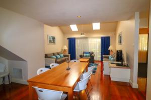 una sala de estar con una gran mesa de madera y sillas en Oystercatcher Executive 3 Bedroom Villa 23, en Cams Wharf